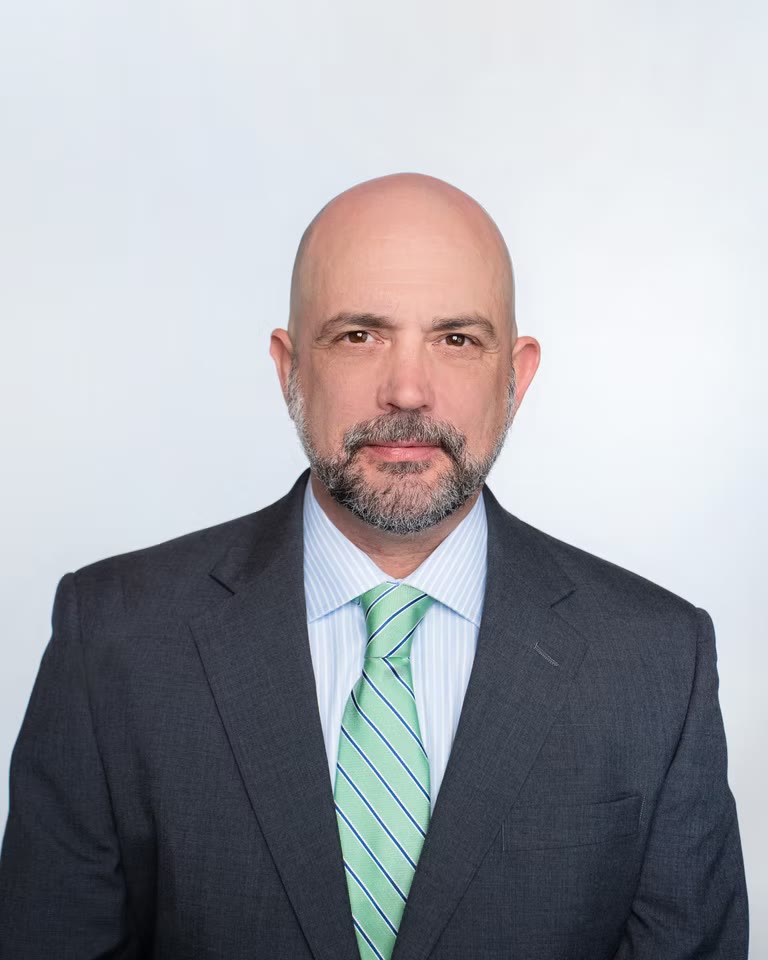 Corporate headshot, grey suit and green tie