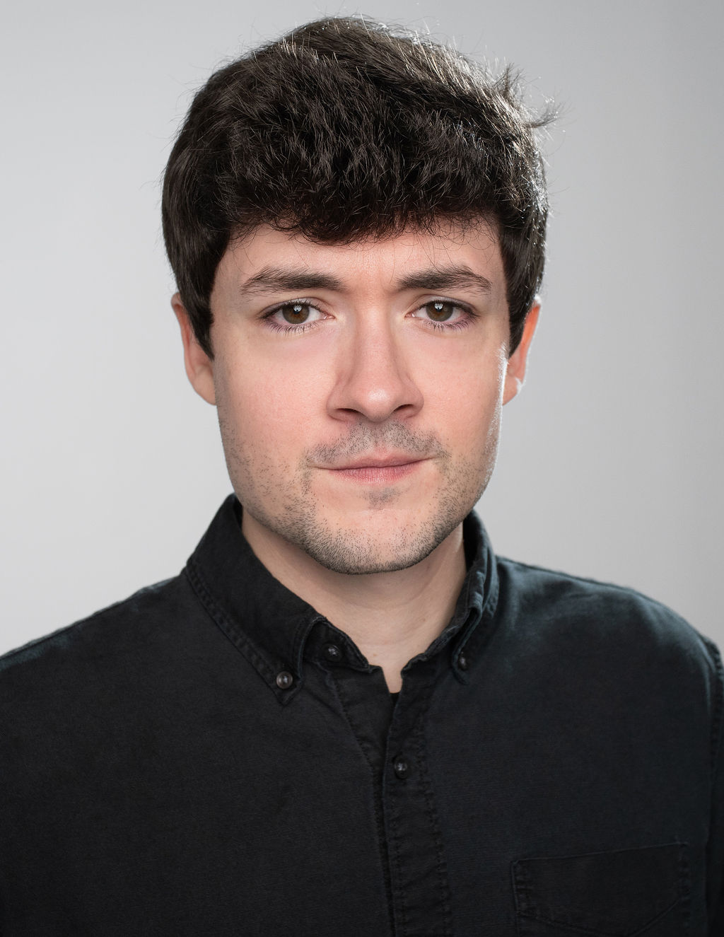Jeffery, high-key headshot in black jacket