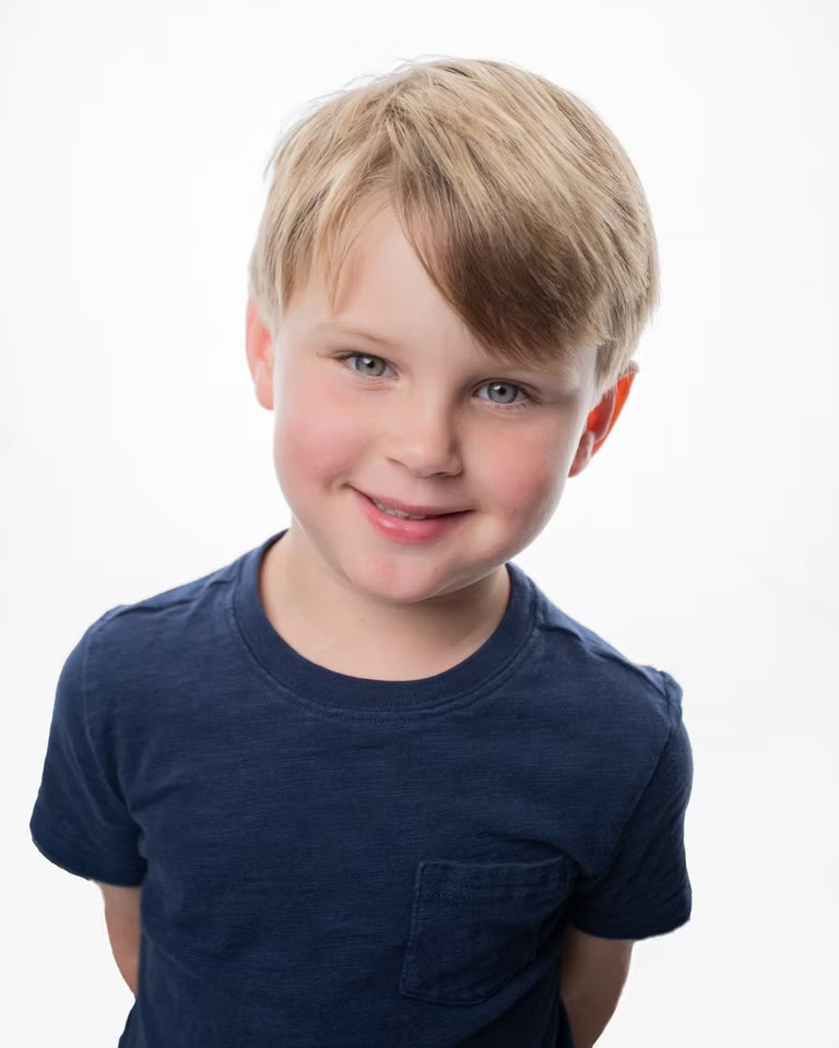 Child headshot, navy tee on high-key white