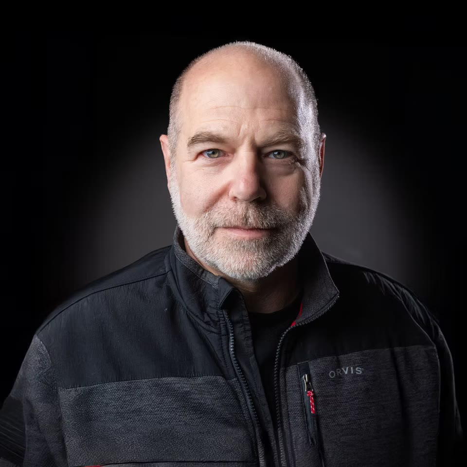 Low-key portrait on black, soft rim light