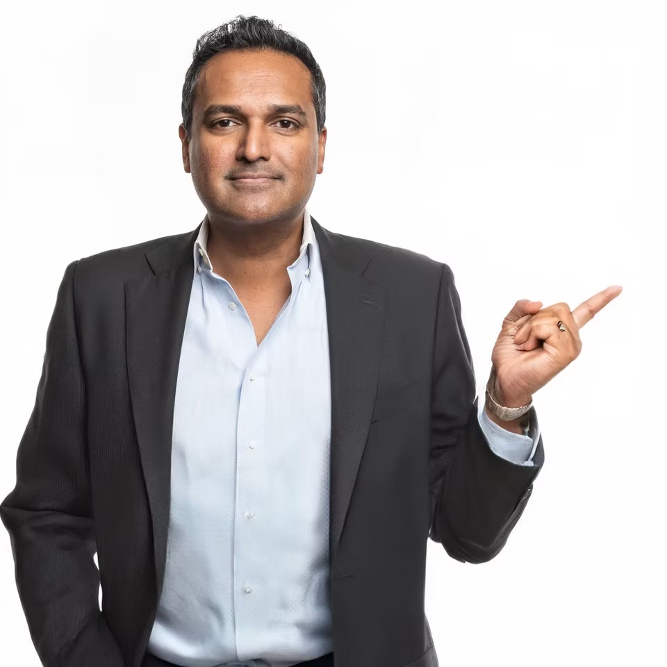 Energetic personal brand portrait, pointing, grey suit