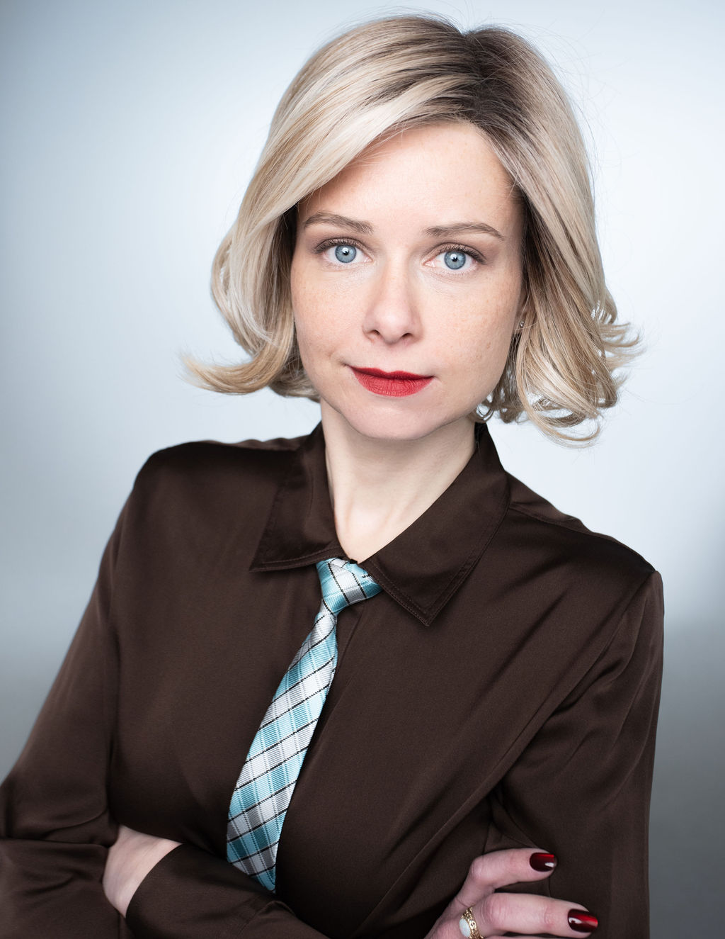 Kelly, editorial headshot with arms crossed